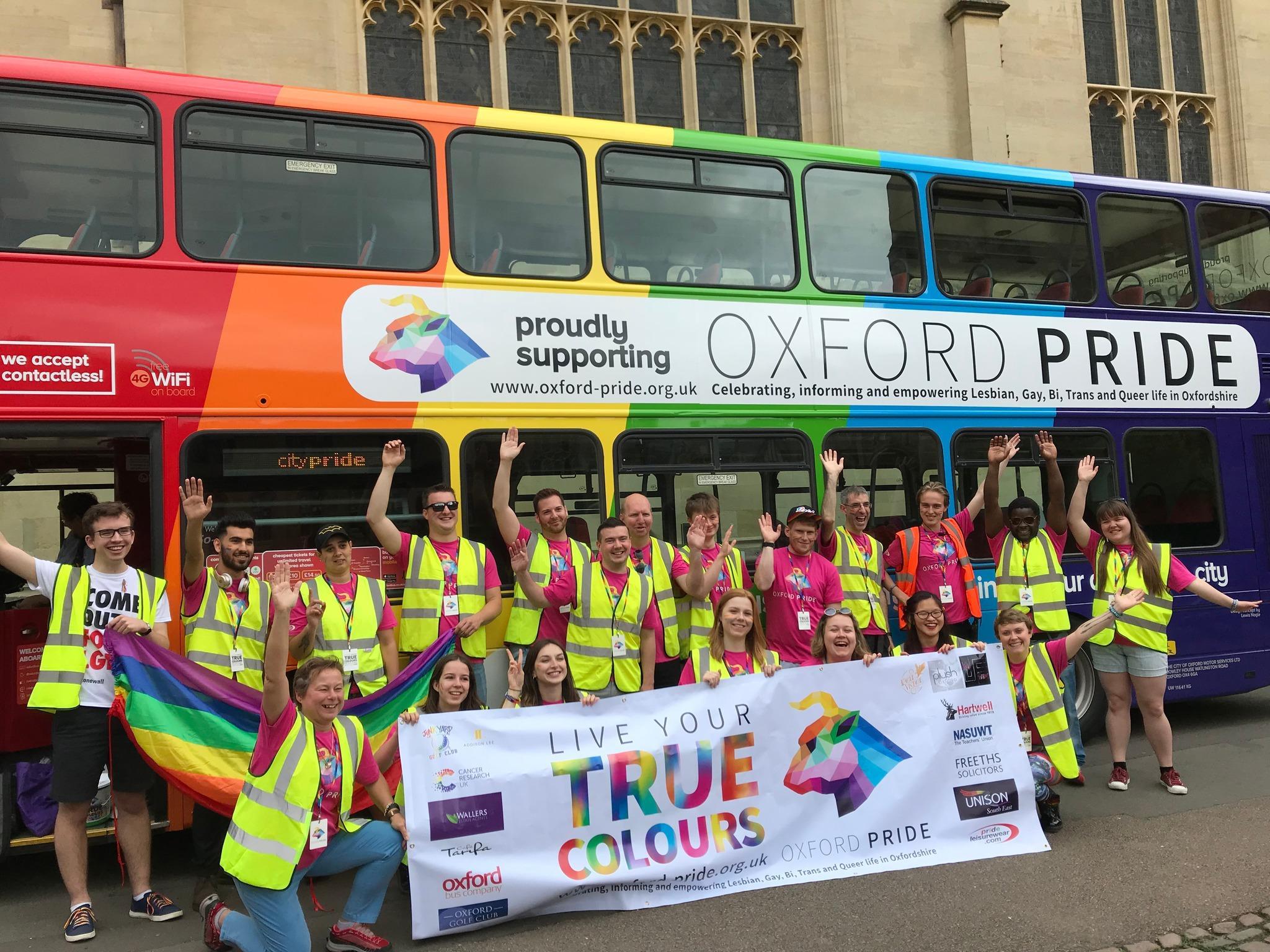 Volunteers cheering in front of the Oxford Pride bus