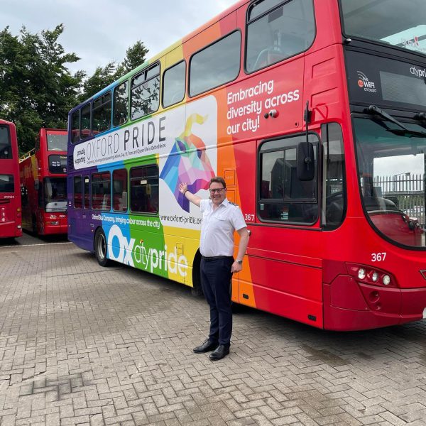 Driver pointing at the Oxford Pride bus